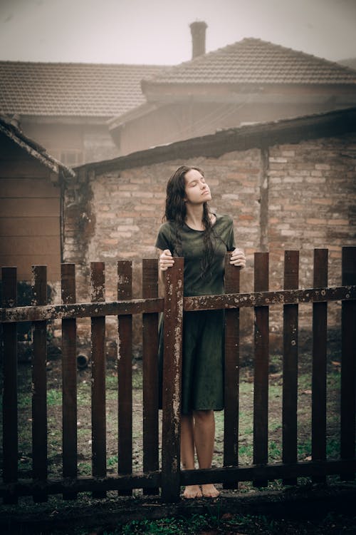 Free Woman Standing Beside Fence Stock Photo