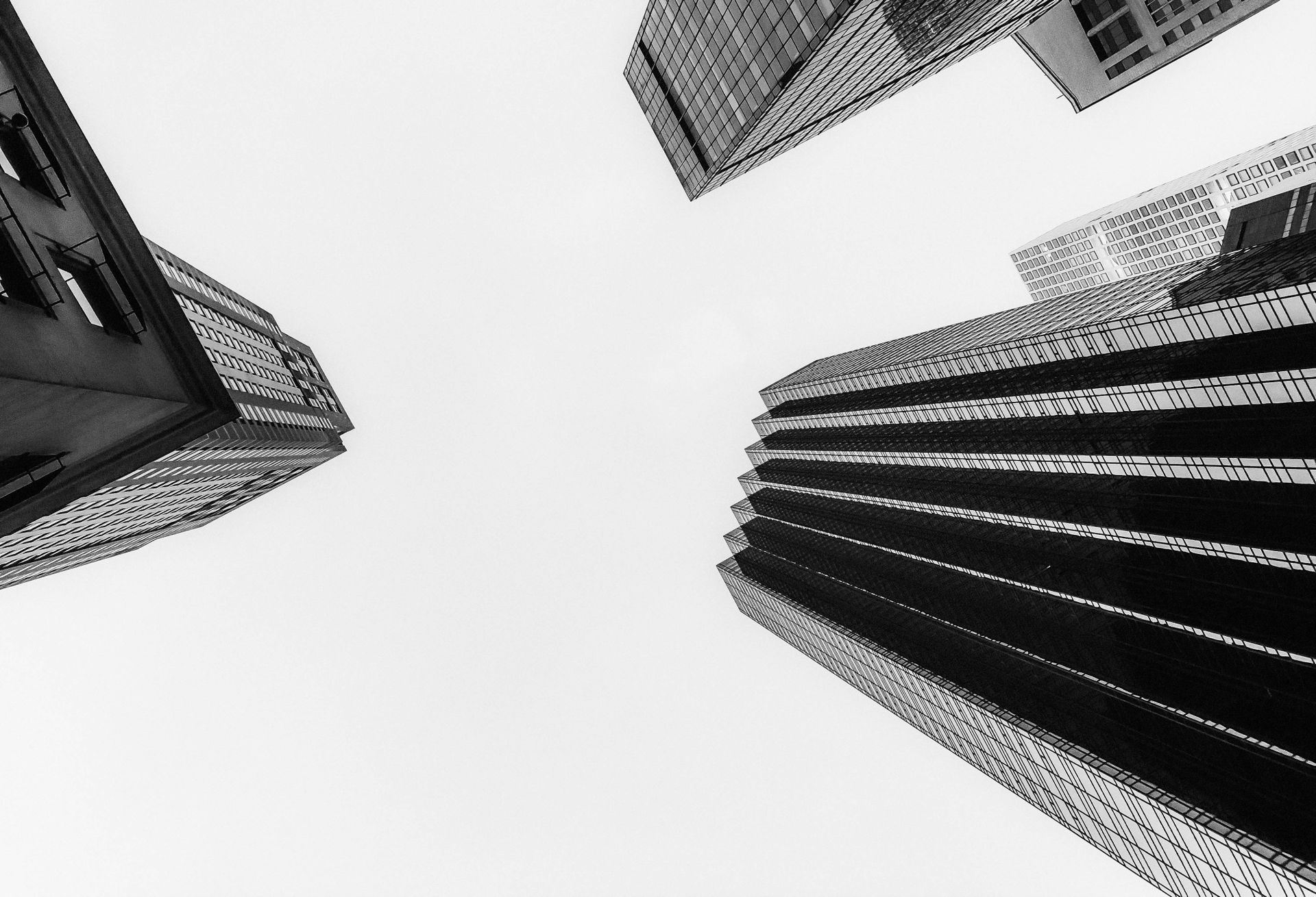 Black and white view of skyscrapers converging in New York City, showcasing modern architecture.