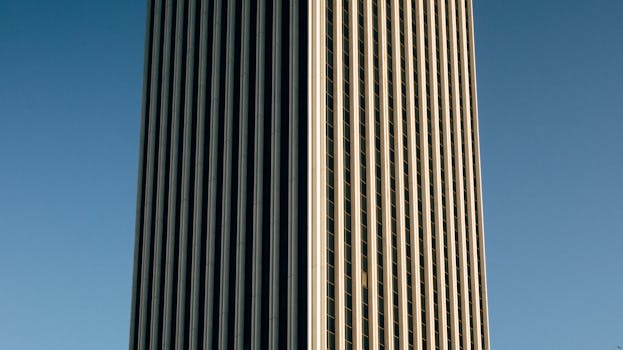 晴朗蓝天下，一栋现代摩天大楼的垂直线条特写