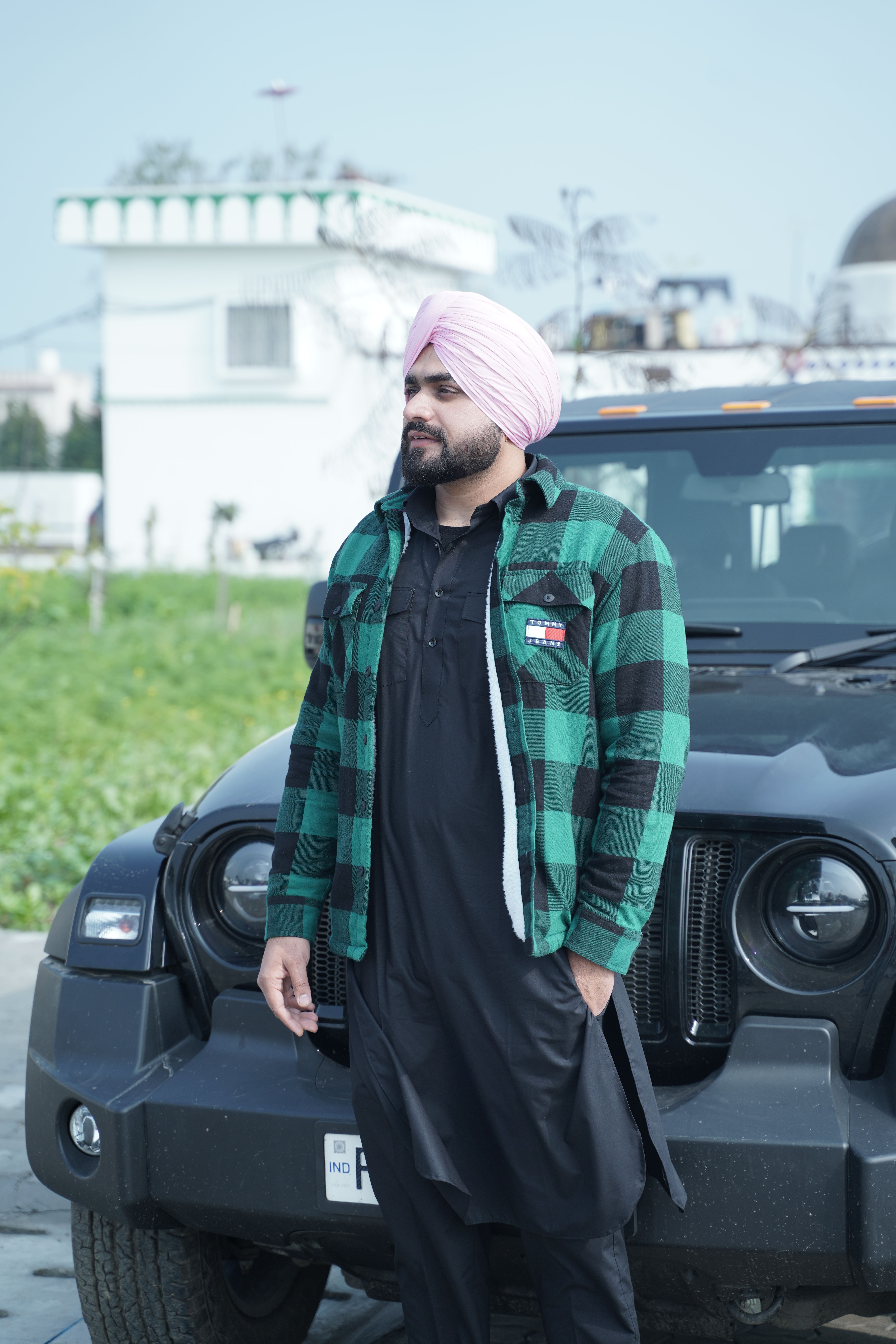 Man in traditional attire with jeep, showcasing outdoor lifestyle.