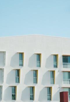 极简主义的公寓门面与几何窗口图案映衬着晴朗的天空