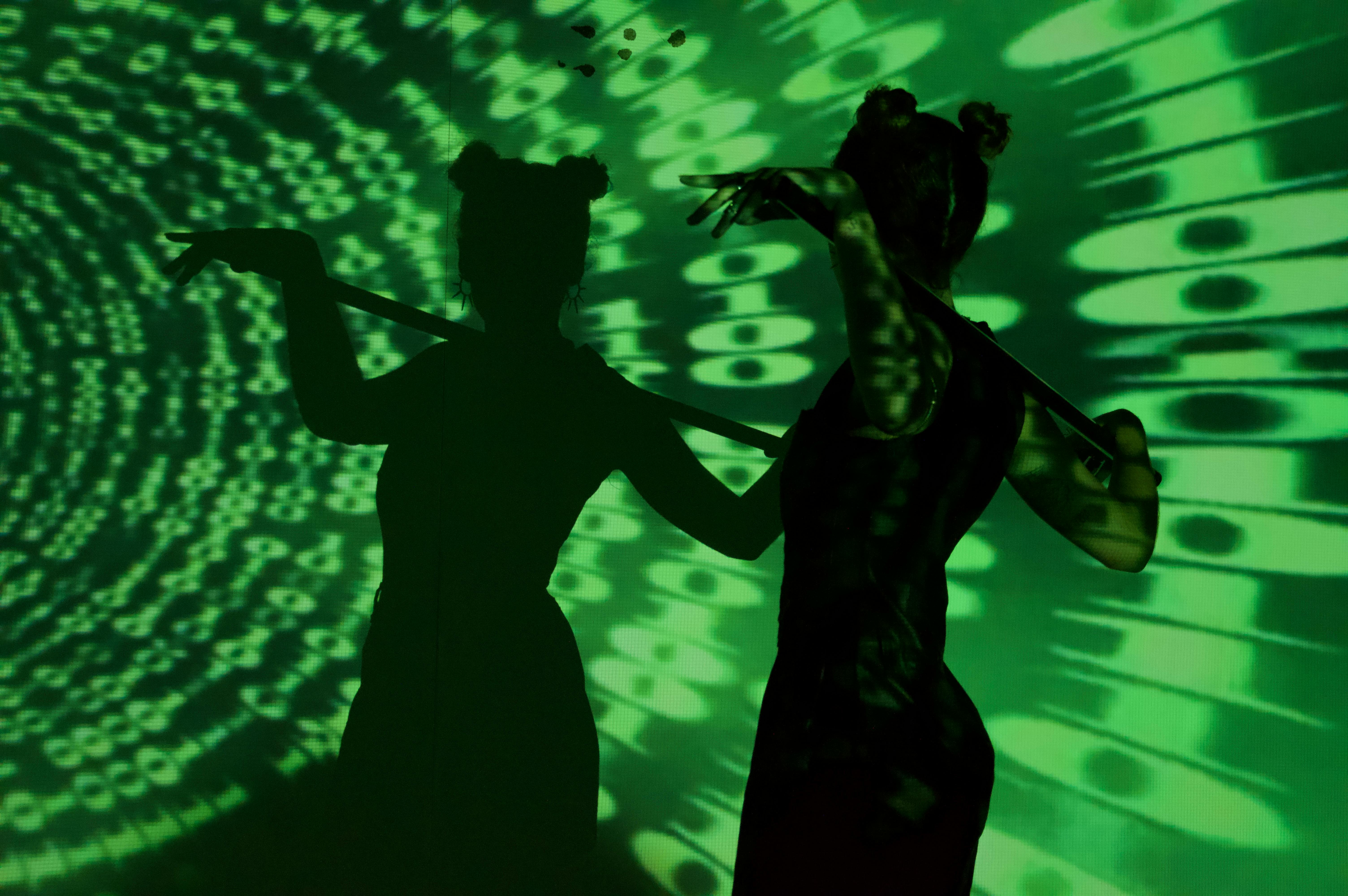 Artistic silhouette of a woman with digital green light projections creating a cyberpunk atmosphere.