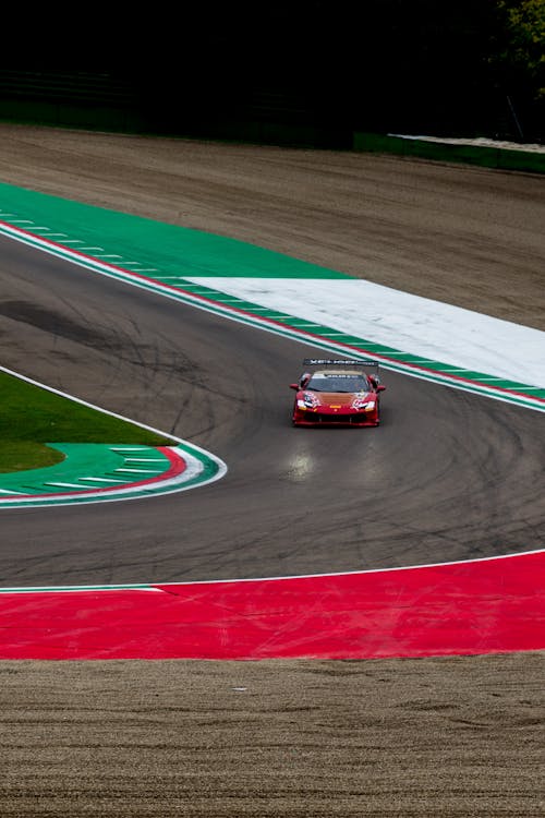 Red Sports Car Racing on Curved Track · Free Stock Photo