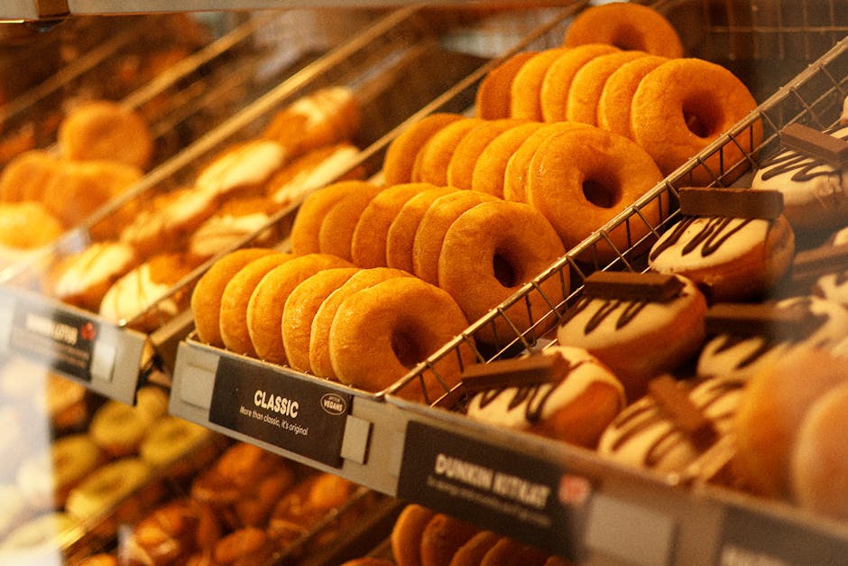 A tempting display of classic and chocolate donuts arranged on bakery trays.
