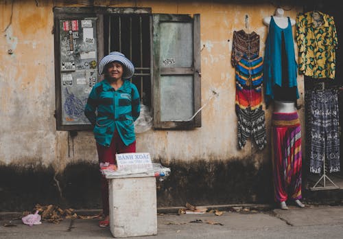 Female Vendor Stands Near Open Window