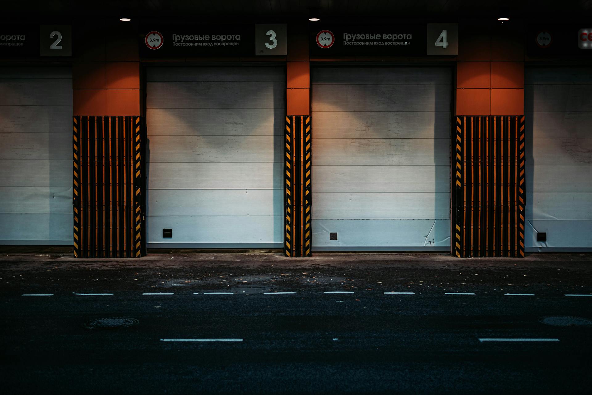 Night view of a modern loading dock with closed garage doors in an urban area, showcasing industrial architecture.