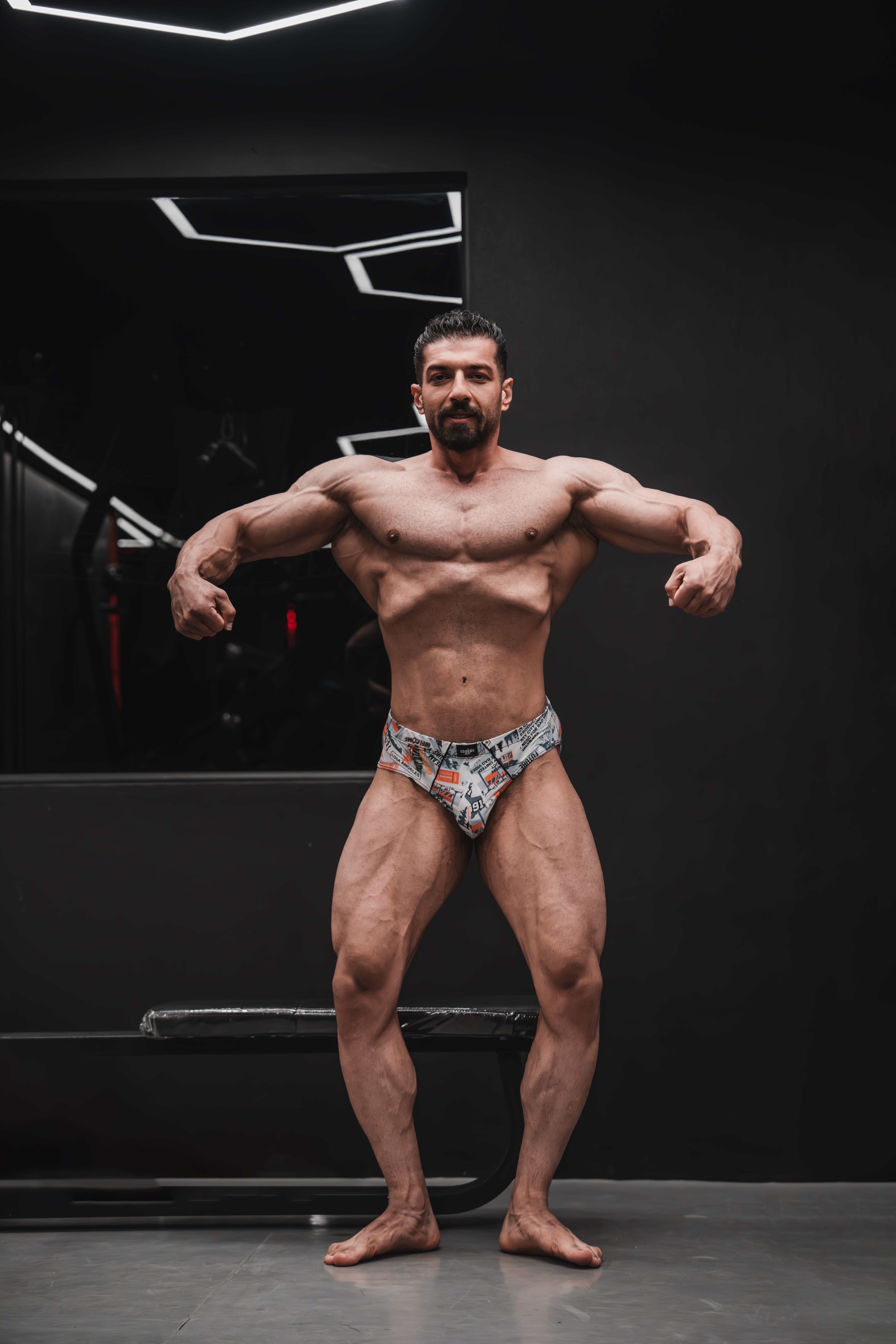 Portrait of a professional bodybuilder posing confidently inside a modern gym.