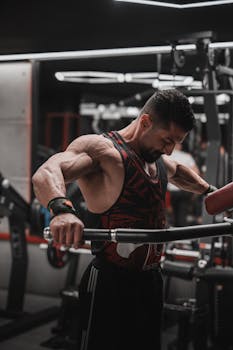 Muscular man in gym performing lat pulldown exercise with focused intensity.