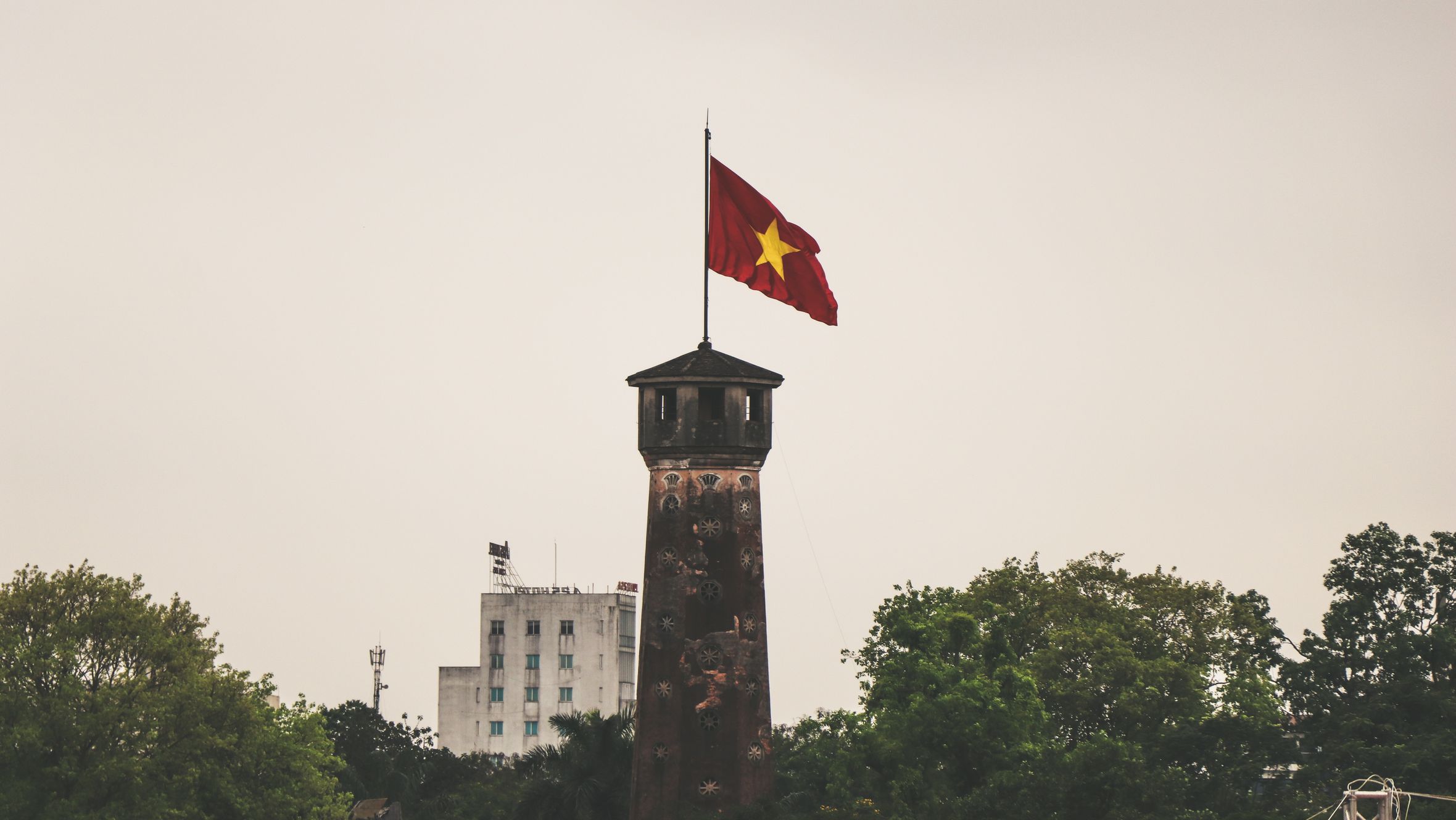 Historic flag tower with the Vietnamese flag prominently displayed in Hanoi.