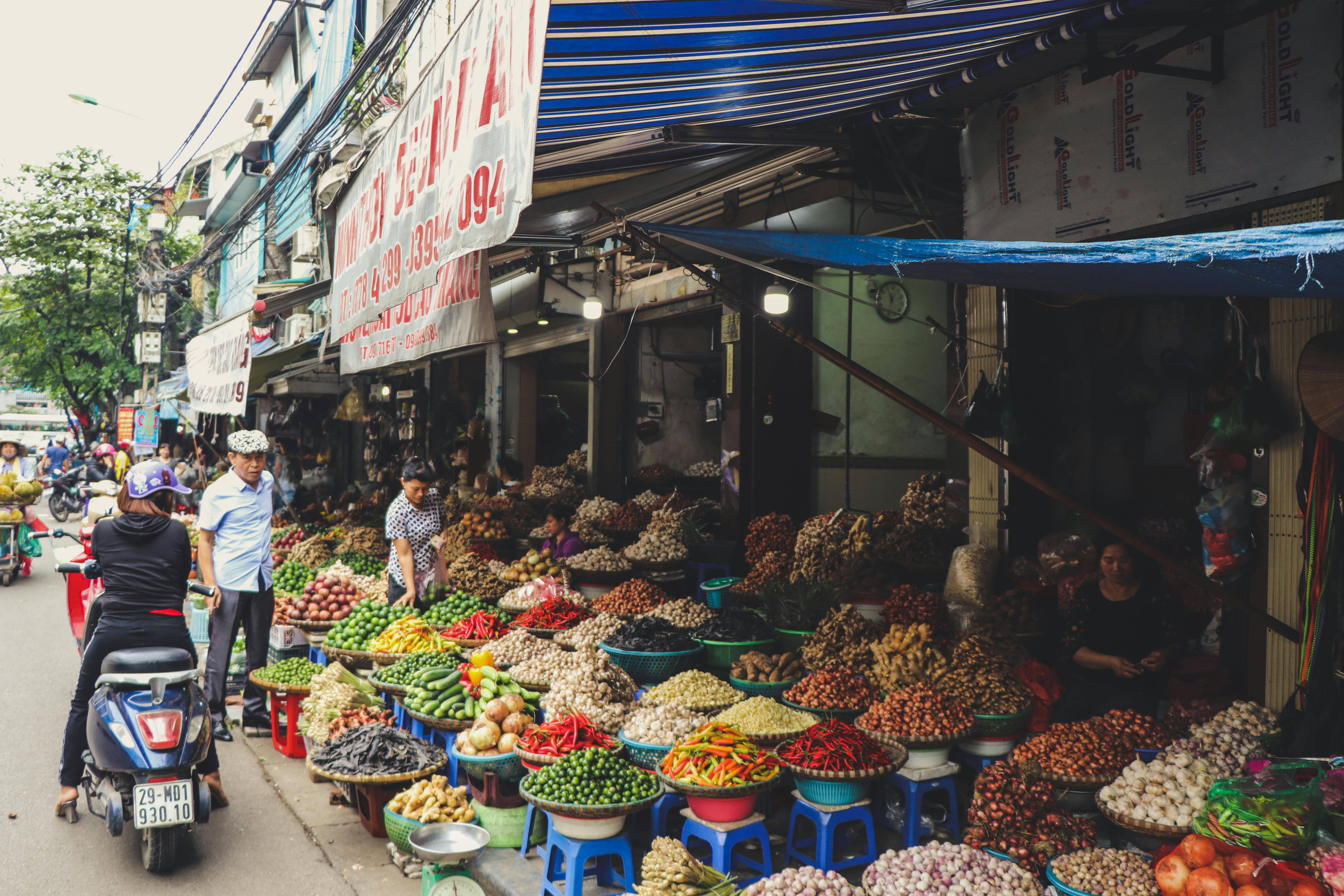 person in scooter in front of vegetables