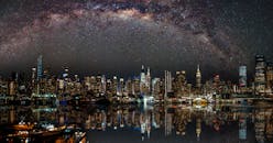 纽约市的夜景中，星星倒映在水面上