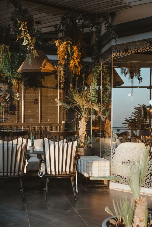Free Charming outdoor terrace with elegant seating, plants, and warm lighting ambiance. Stock Photo
