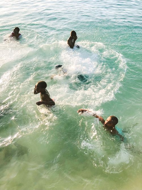 Free Children swimming joyfully in the clear waters, embracing a carefree moment under the sun. Stock Photo