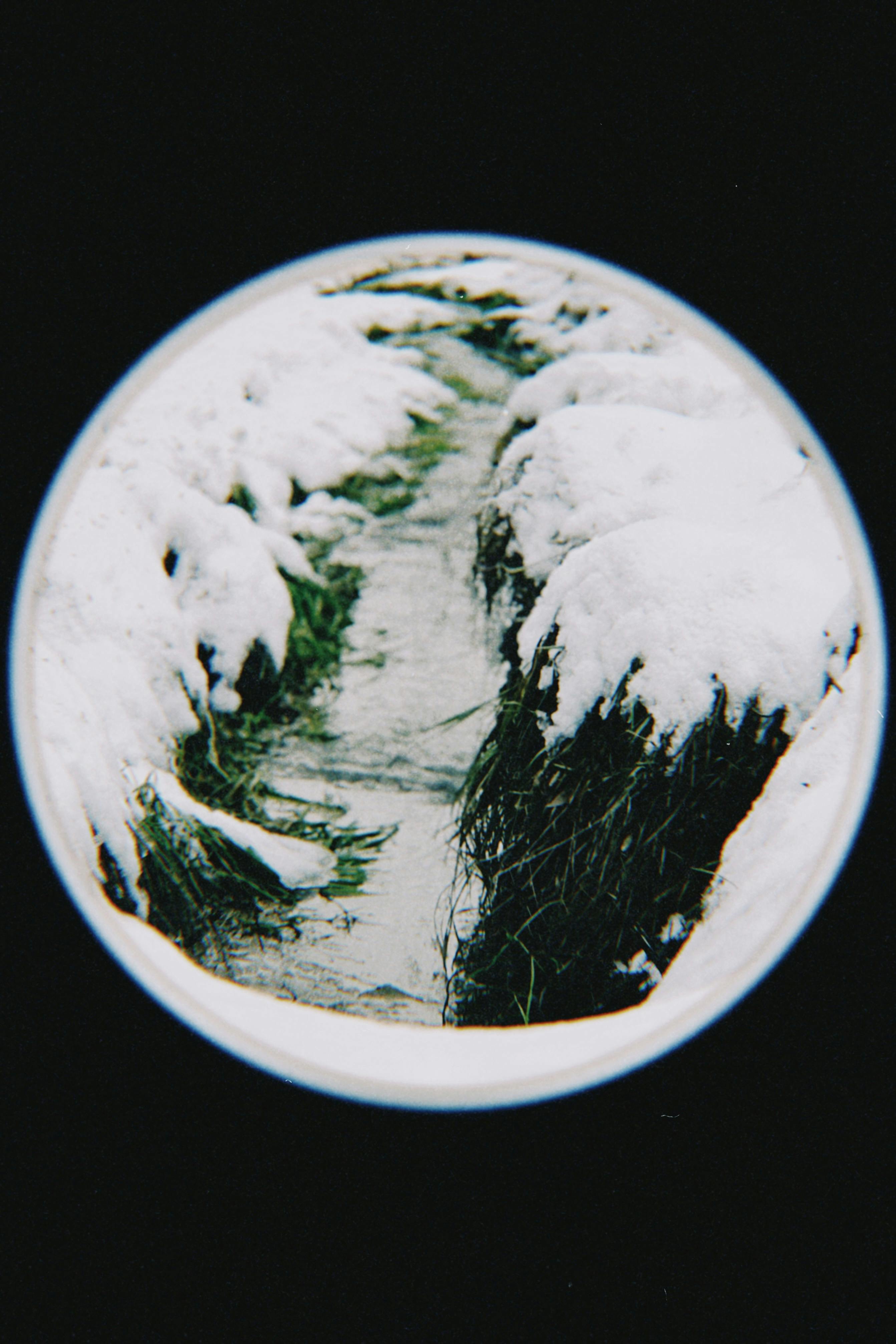 Snow-covered stream viewed through a fisheye lens in Talgar, Almaty Region, Kazakhstan.