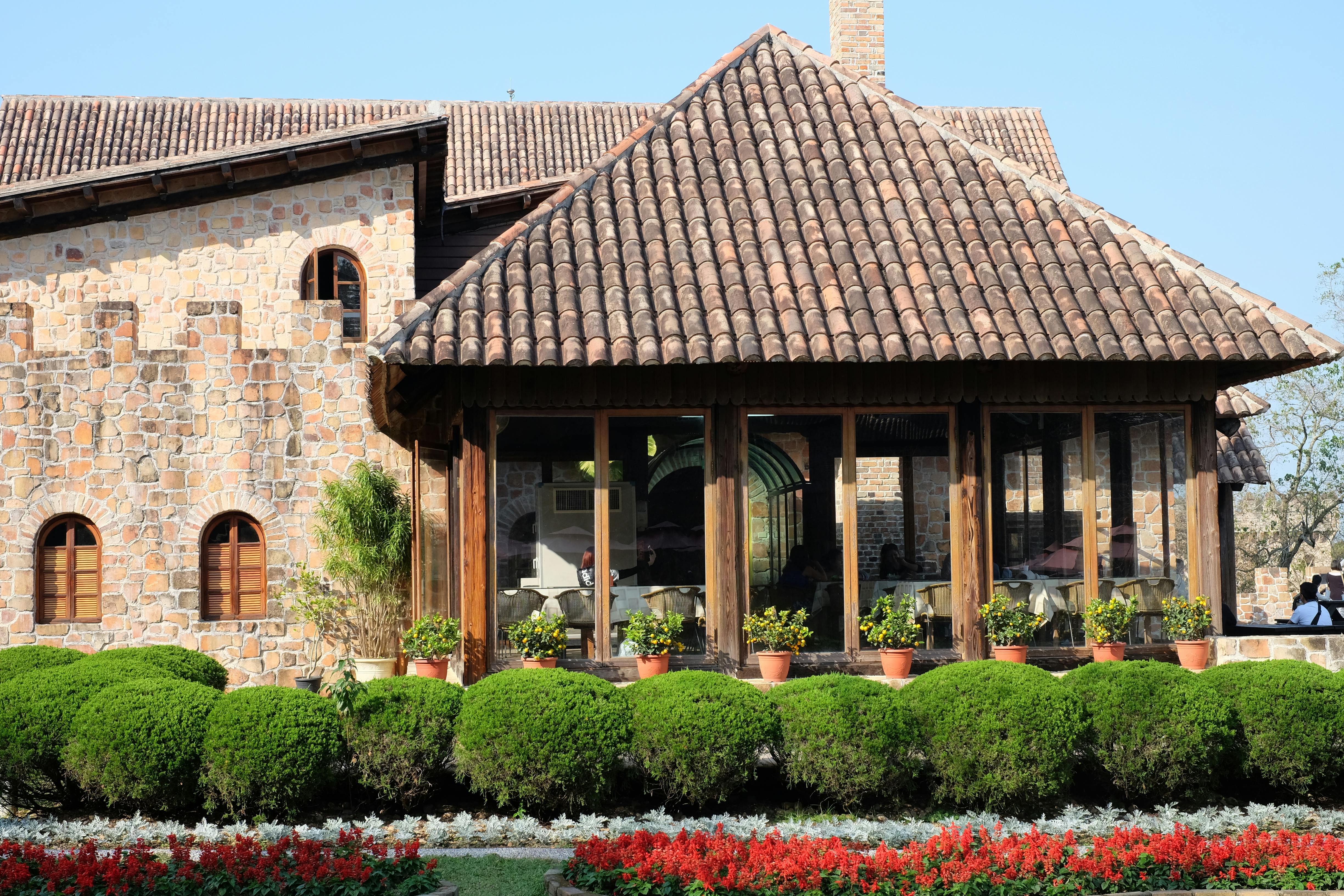 brown house behind green hedge