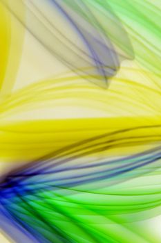 Vibrant abstract light streaks in green and yellow, creating a dynamic flow and movement effect.