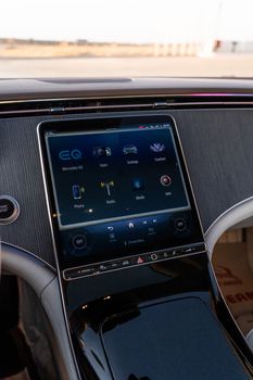 Interior view of Mercedes-Benz EQS featuring advanced touchscreen controls in a luxury setting.