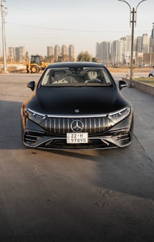Sleek black Mercedes-Benz EQS parked outdoors in an urban area under daylight.