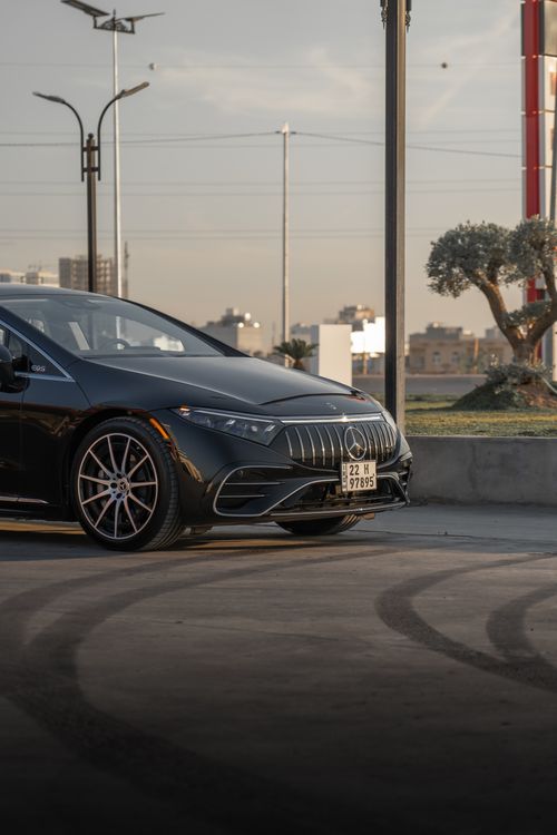 Free Luxury Mercedes-Benz EQS electric car parked outdoors with urban skyline. Captured at dusk, emphasizing innovation and elegance. Stock Photo