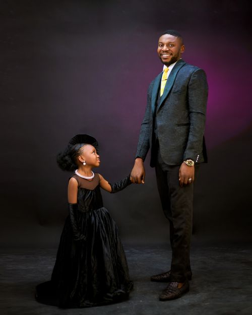Free A stylish father and daughter in formal black dresses share a joyous moment. Stock Photo