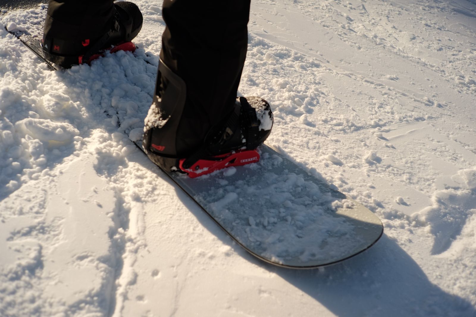 Snowboarder boots and ankles on snow for snowboarding ankle brace selection. Photo: Pexels.