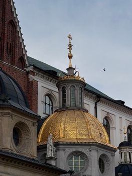 Golden dome against historic architecture with intricate details in a European city.