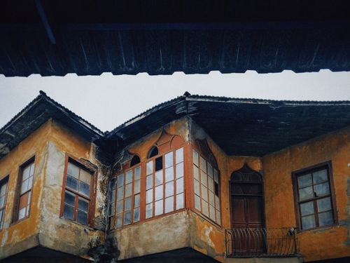 Free Aged building showing rustic architecture with a worn facade and vintage windows. Stock Photo