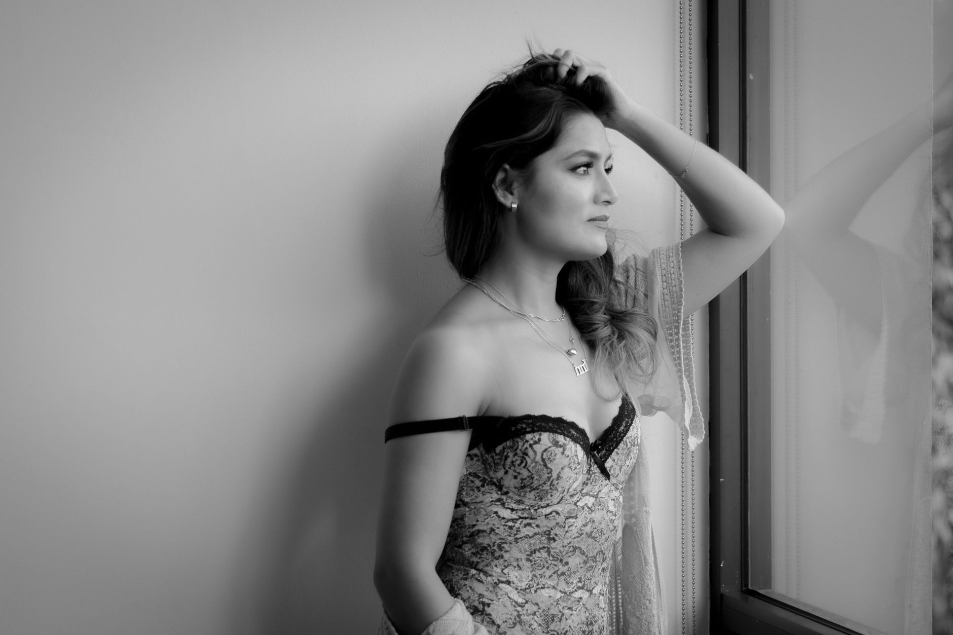 Elegant black and white portrait of a woman gazing out a window in Mexico City.