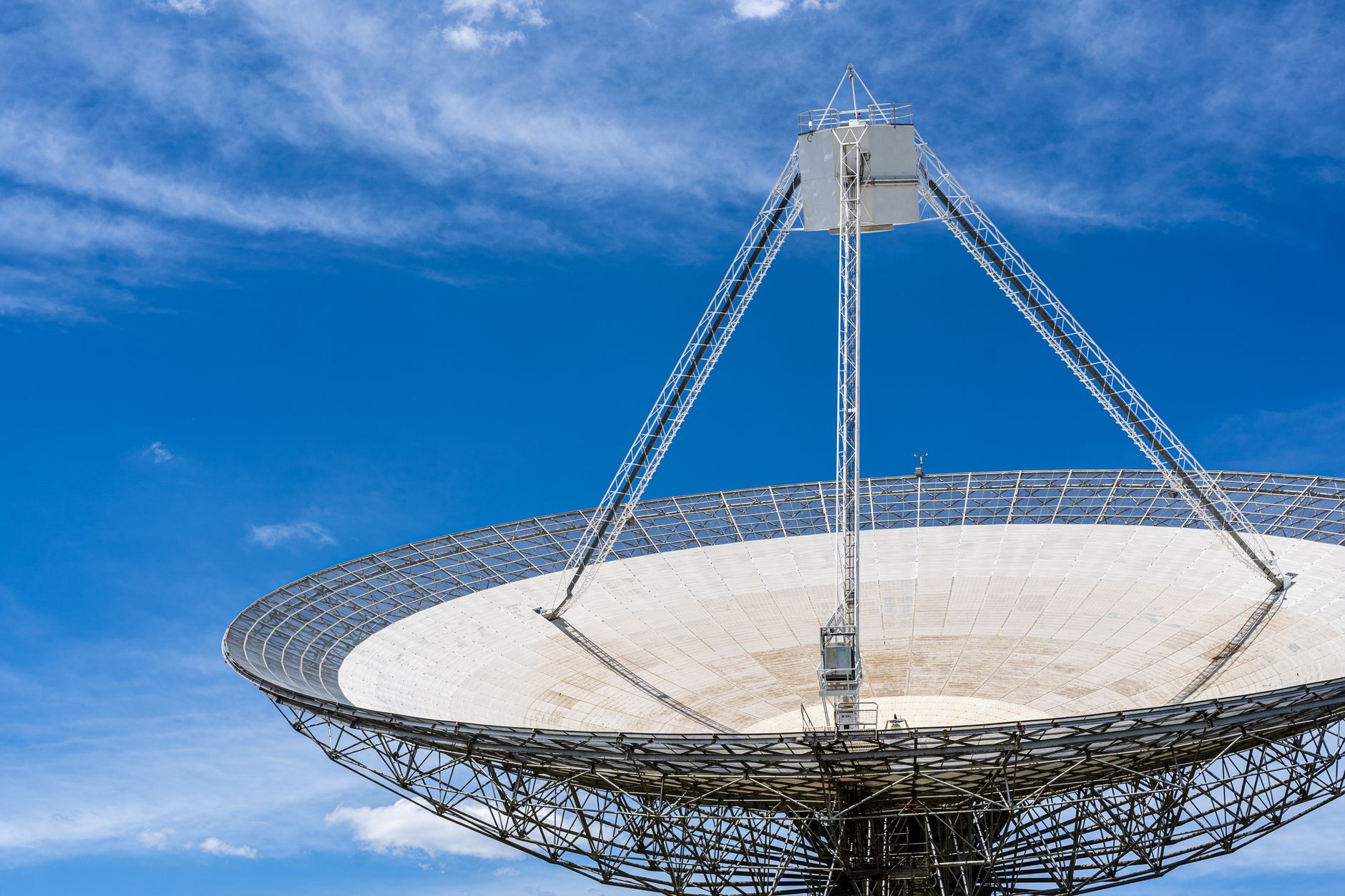 A large satellite dish with a clear blue sky in the background, showcasing modern communication technology.