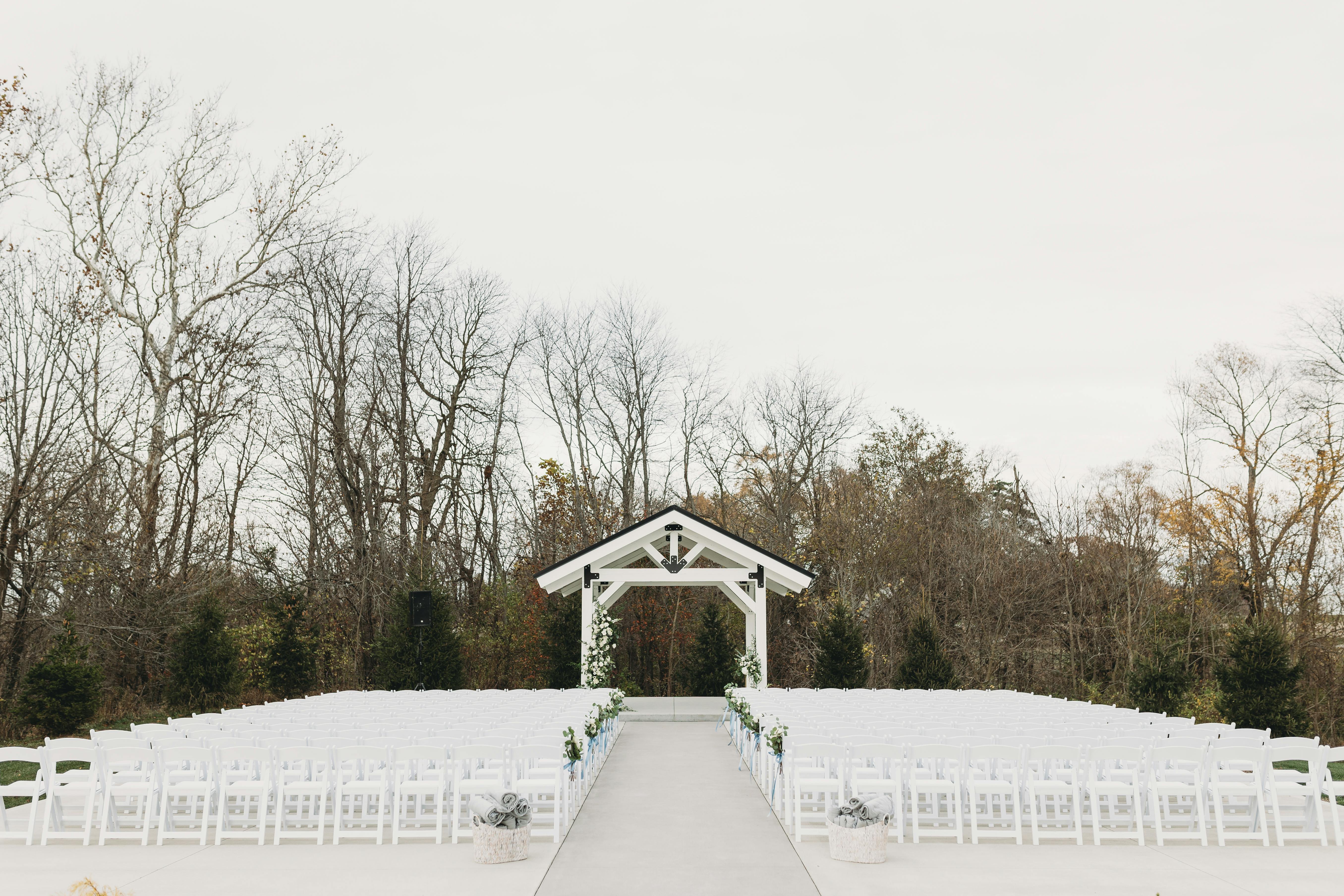 Serene outdoor wedding venue with chairs and arch in natural setting.