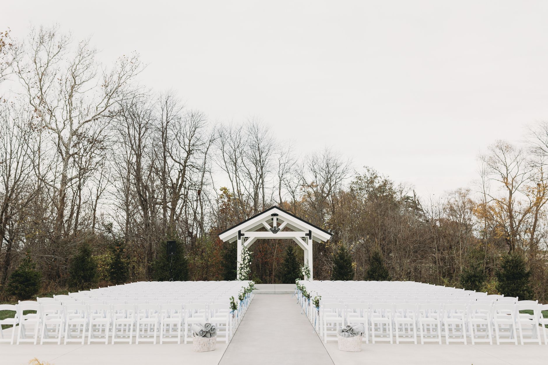 Serene outdoor wedding venue with chairs and arch in natural setting.