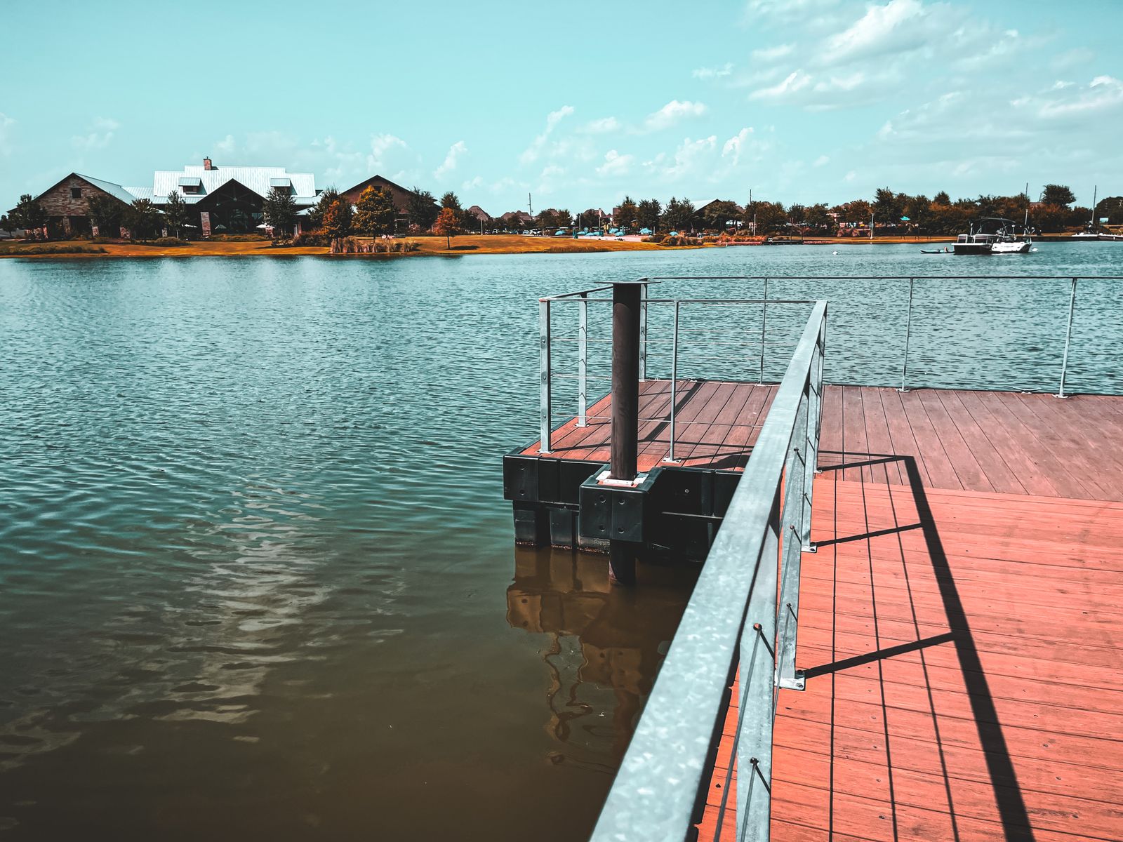 Orilla de lago con muelle de madera al atardecer