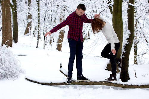 Man and Woman Standing on Wood Branch