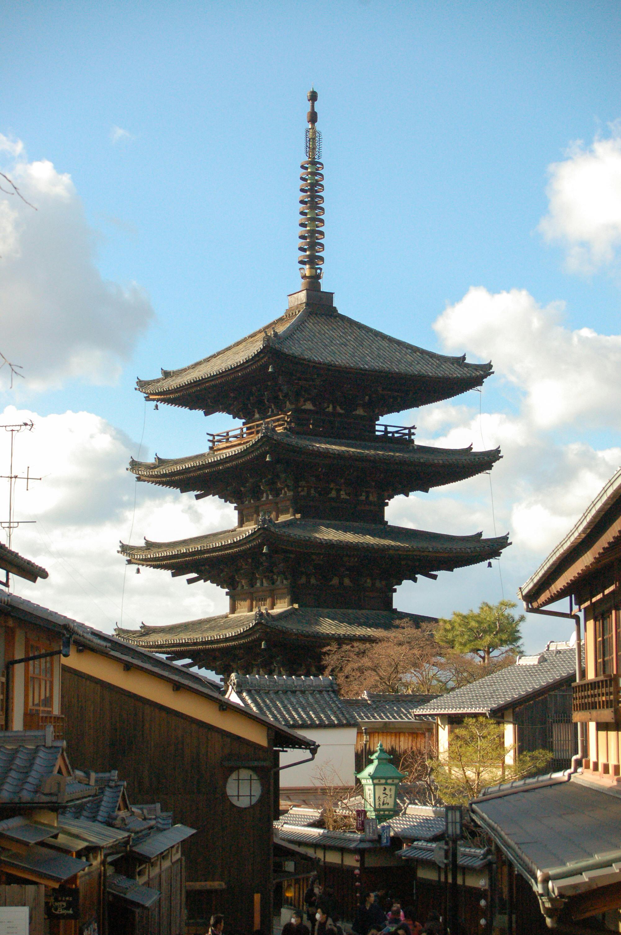 Iconic Yasaka Pagoda in Kyoto surrounded by historic wooden buildings under a clear sky.