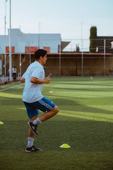 A young male athlete in a sports field during daylight practice.