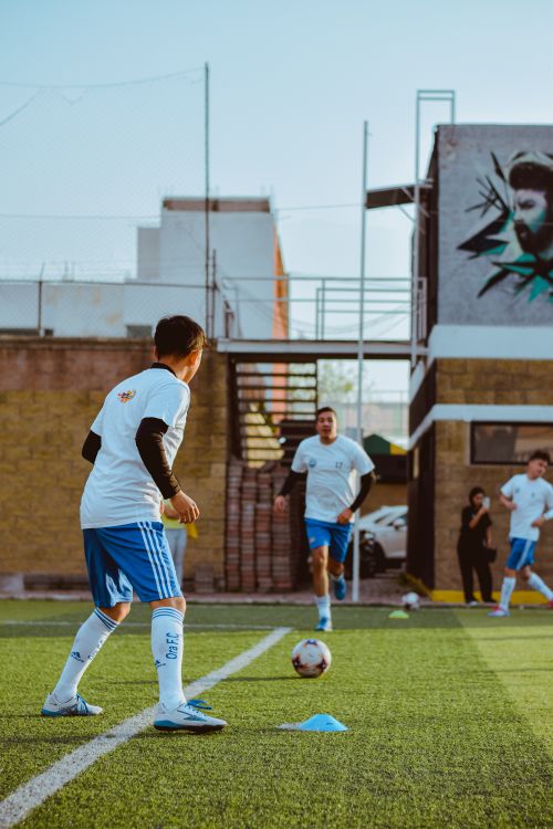 Free Boys playing soccer on an urban field, showcasing teamwork and sportsmanship. Stock Photo