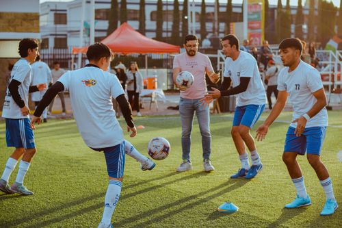 Free Group of young men practicing soccer drills on an outdoor field, preparing for a game. Stock Photo