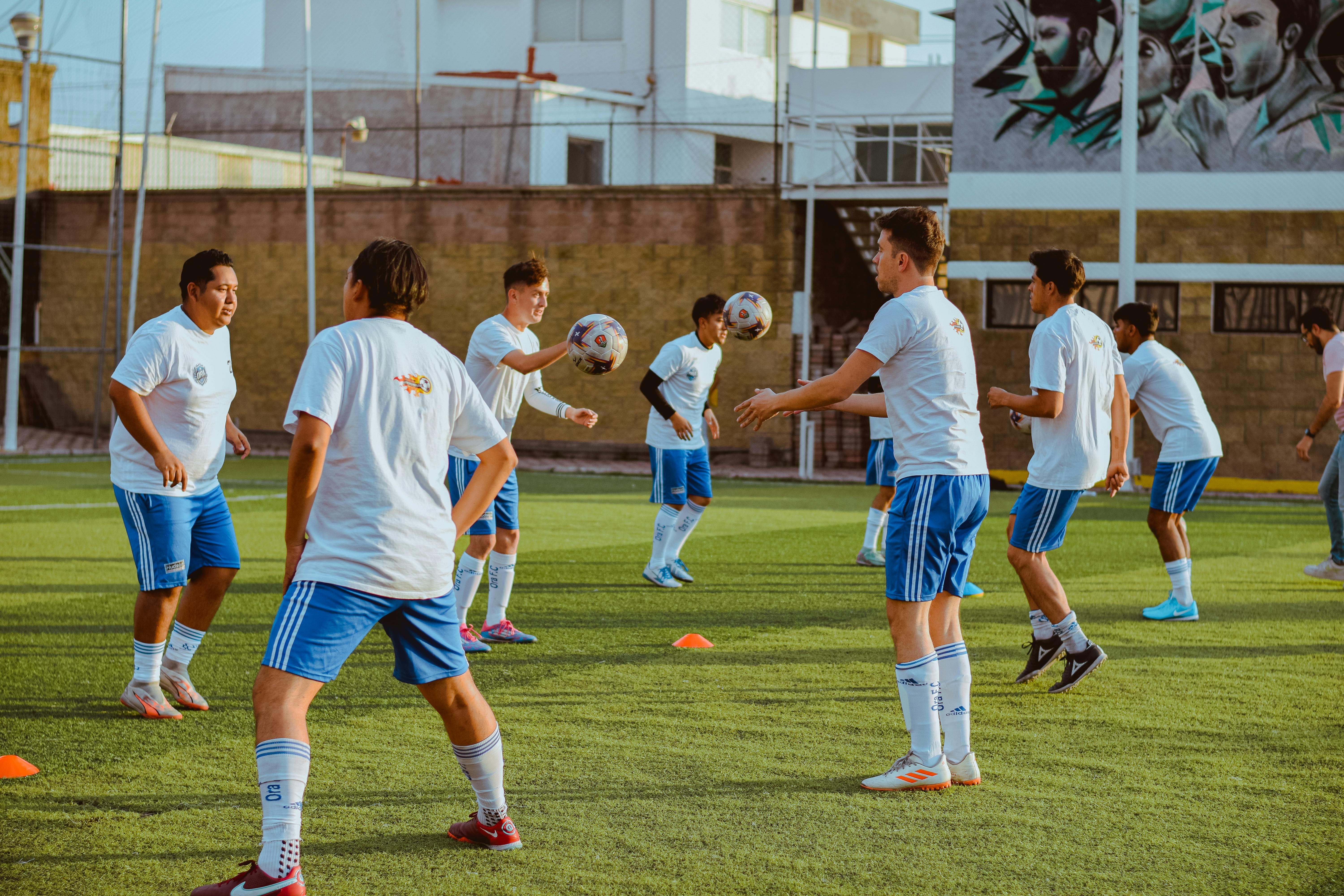 Group of young men practicing soccer on an outdoor field.