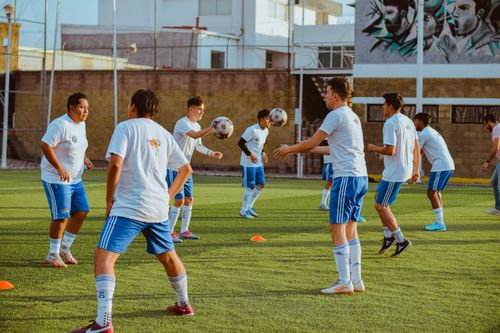 Free Group of young men practicing soccer on an outdoor field. Stock Photo