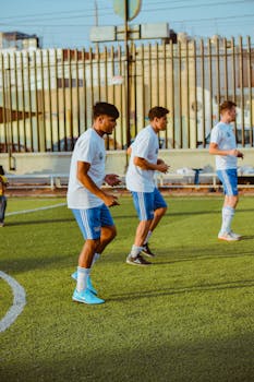 Group of young male soccer players training on a city field.