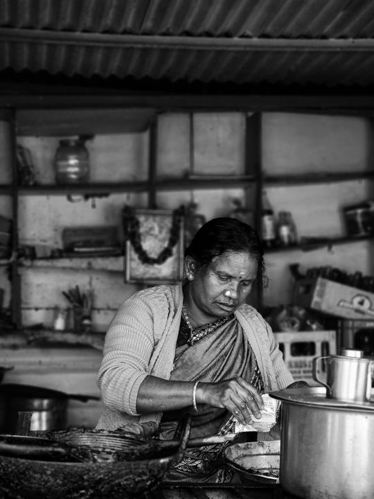 Jain Cooking Classes in Ahmedabad: What You Learn, Where to Go, and Why It Matters (2026) 2 A South Asian woman preparing food in a traditional Indian kitchen, learning authentic Jain cooking techniques for everyday and festive meals.