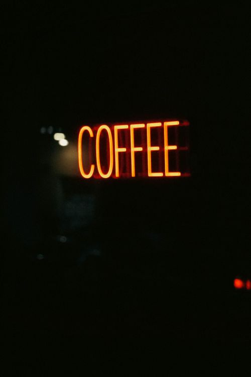 Free Moody neon coffee sign in a dark backdrop, perfect for café lovers. Stock Photo