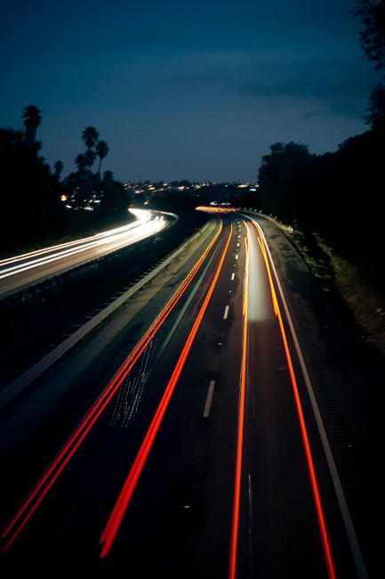 Fotomural Impresionante fotografía de larga exposición que captura estelas de luz en una carretera al anochecer en Pismo Beach, California.
