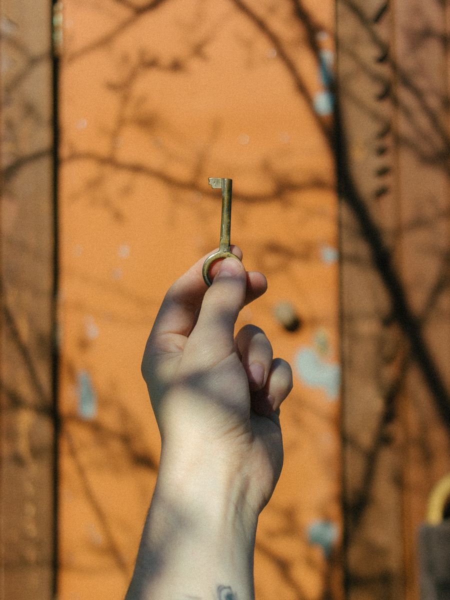 A real hand holding a real key at a real door
