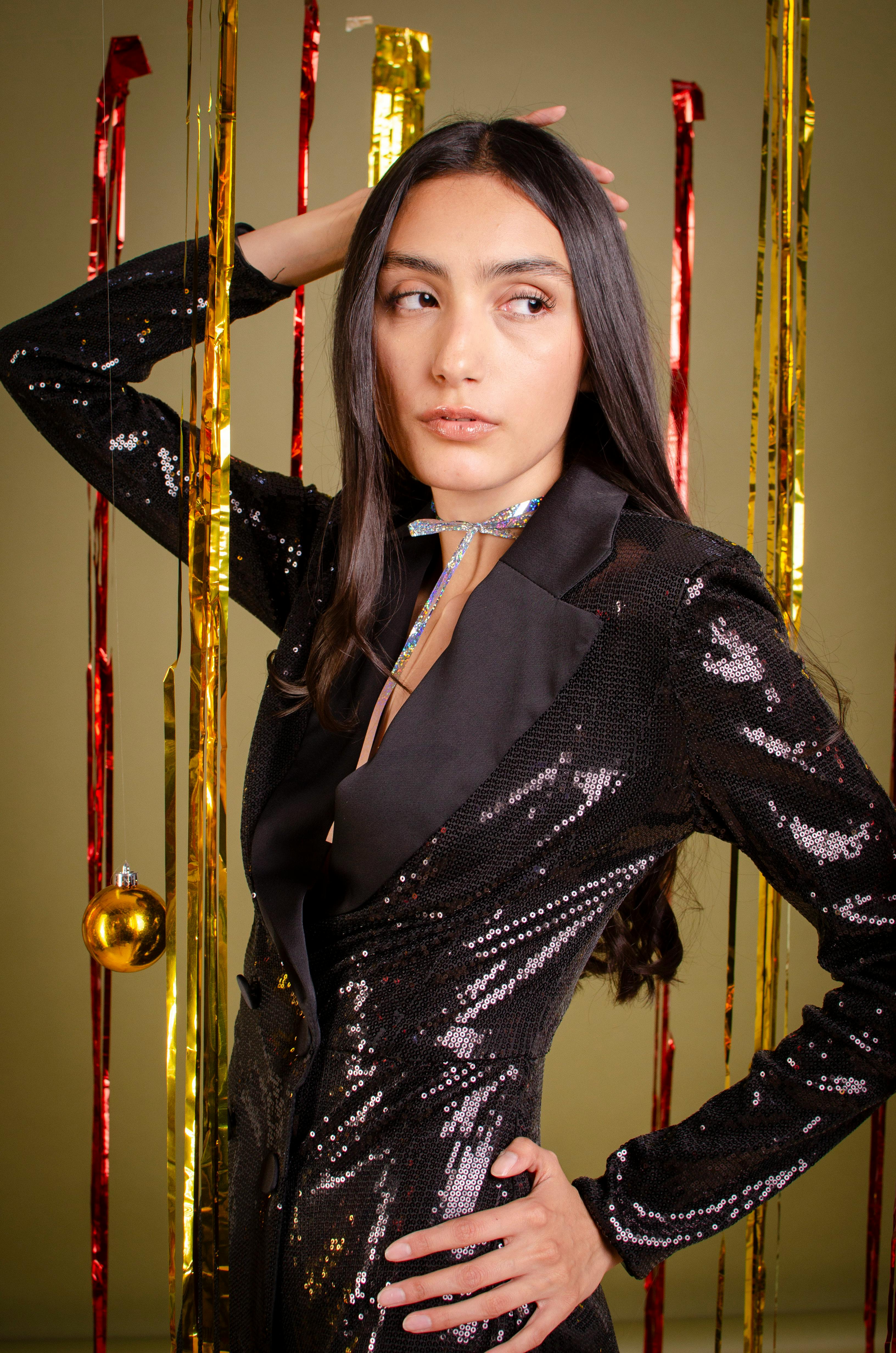 bezplatná Módní žena ve flitrové bundě pózuje se slavnostní výzdobou. Základová fotografie