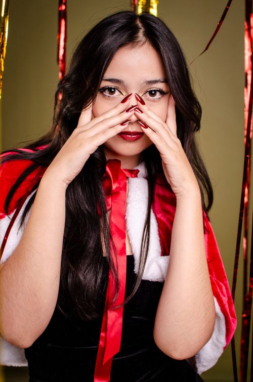 Free Elegant portrait of a woman in a Santa cape celebrating Christmas with red nails. Stock Photo