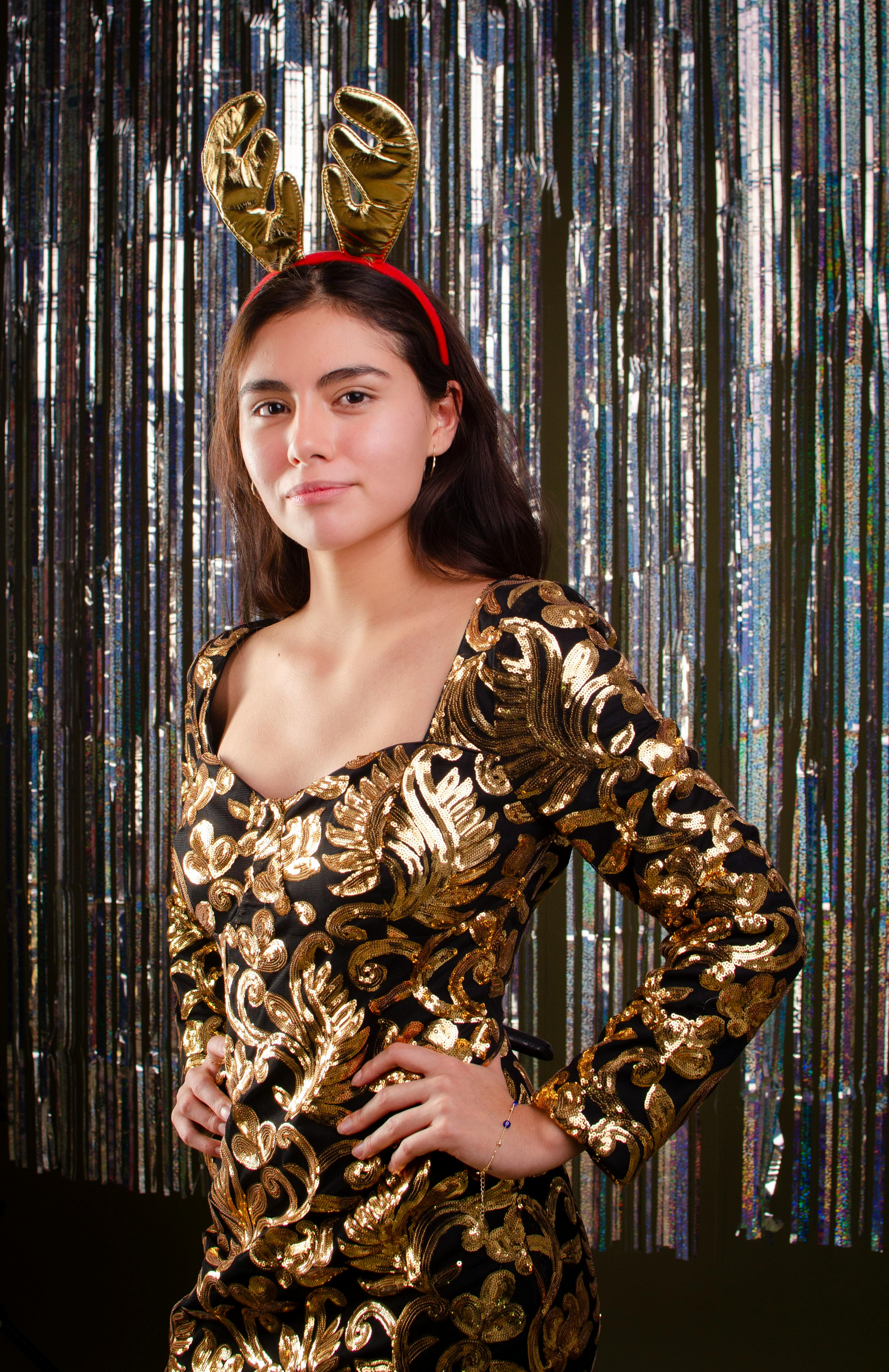 Free Elegant portrait of a woman in a gold dress with reindeer antlers. Perfect for holiday themes. Stock Photo