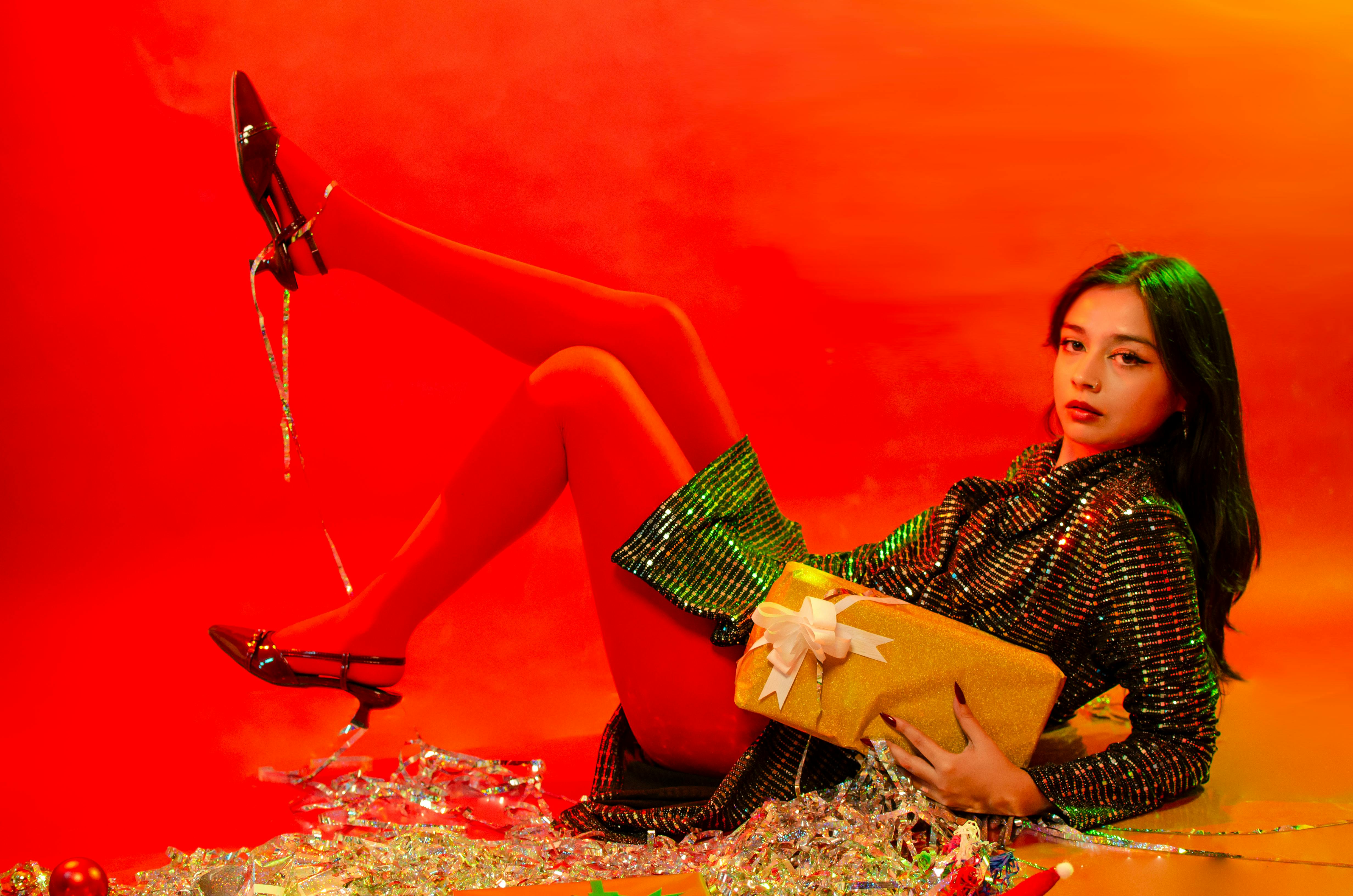 Ücretsiz Şık bir kıyafet içinde hediye tutan bir kadının canlı bir tatil portresi. Stok Fotoğraflar