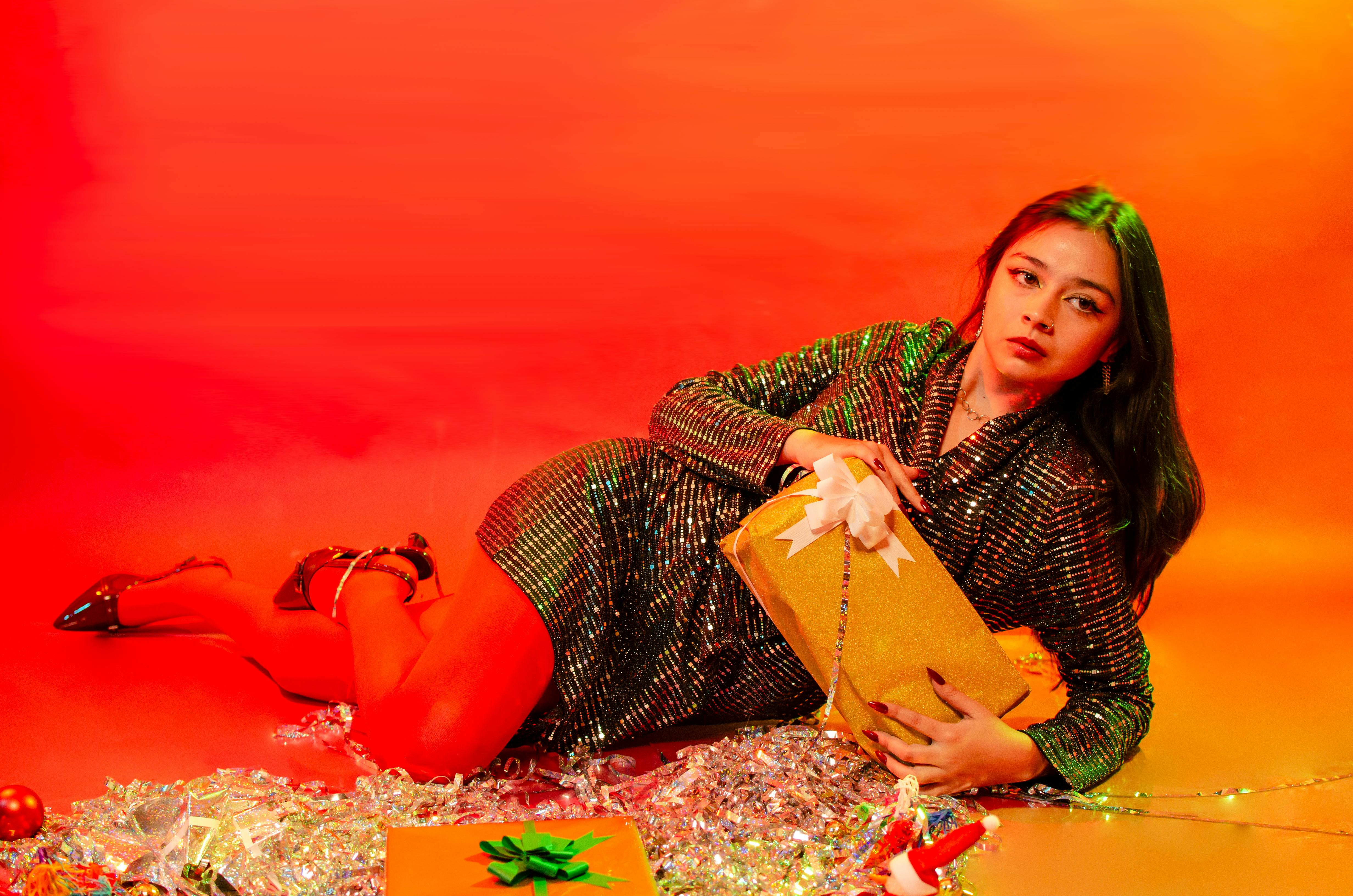 Gratis Wanita modis berpose dengan hadiah liburan dalam pencahayaan yang terang. Foto Stok