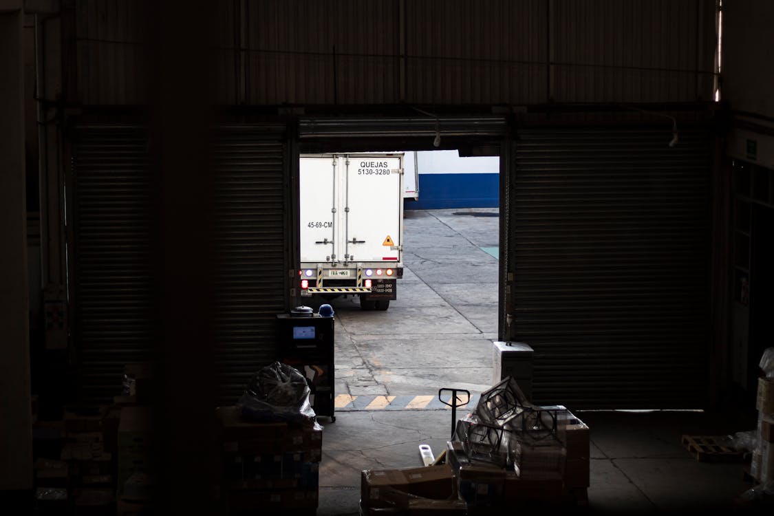 Warehouse with Delivery Truck Exiting the Loading Dock · Free Stock Photo